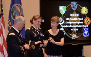 Maj. April M.K. Moore receives the Roman Gladius sword, signifying her selection as the LTC Ronald C. Ward Distinguished Special Operations Forces Student Award for the Command and General Staff Officer Course Class of 2016. Presenting is Col. Paul Schmidt, director of the Combined Arms Center Special Operations Forces Directorate, and Ms. Beth Ward, wife of the late Lt. Col. Ward.