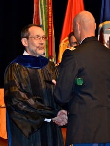 Dr. Baumann congratulates a SAMS student during a graduation ceremony in Eisenhower Hall. 