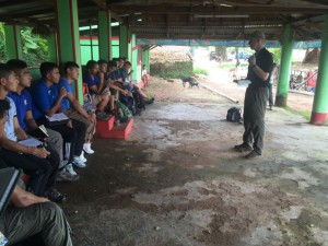 The group gets a class on the 1942 battle while sitting in a hut at Sittang Bridge. (photo by Geoff Babb)