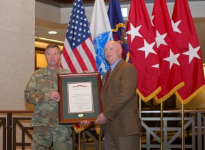 Gen. David Perkins, commander of U.S. Army Training and Doctrine Command, presents the Army Superior Unit Award  to retired Col. Mark McKnight, director of the School for Command Preparation Dec. 1 at the Lewis and Clark Center.