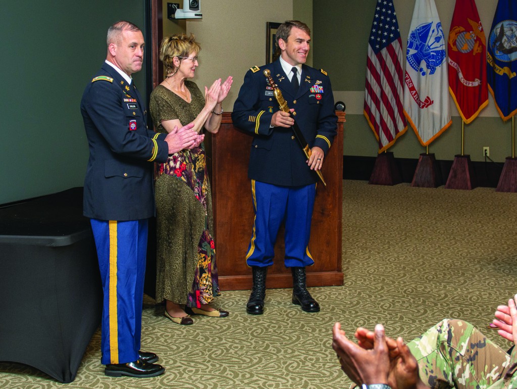 Attendees applaud as Maj. William J. Doyle receives the Roman Gladius sword, signifying his selection as the LTC Ronald C. Ward Distinguished Special Operations Forces Student Award for the Command and General Staff Officer Course Class of 2018 in a ceremony May 29 in the Arnold Conference Room of the Lewis and Clark Center. Presenting is Ms. Beth Ward, center, wife of the award’s namesake, and Lt. Col. Christopher Schilling, an instructor in the CGSS Special Operations Forces Cell. (photos by Dan Neal/ArmyU Public Affairs)