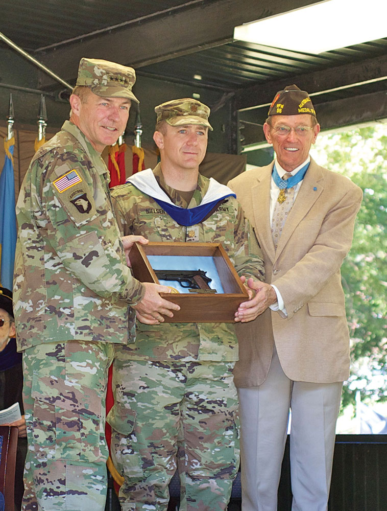 Major Jonathan Nielsen receives the General George C. Marshall Award as the top U.S. graduate from Army Vice Chief General James C. McConville, left, and Col. (Ret.) Roger Donlon, Medal of Honor Recipient, who is also a former member of the CGSC faculty and a founding trustee of the CGSC Foundation.