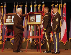 Rep. Leonard Boswell of Iowa along with CGSC Commandant Lt. Gen. Robert Caslen Jr. and Combined Arms Center Command Sgt. Maj. Philip Johndrow unveil his shadowbox during the CGSC Hall of Fame induction ceremony May 11, 2010, in the Lewis and Clark Center's Eisenhower Auditorium, Fort Leavenworth, Kan. (photo by Prudence Siebert/Fort Leavenworth Lamp)