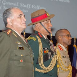 Photo of the three international officers standing at attention on-stage in Eisenhower Hall on April 4, 2019, during the IHOF induction ceremony.