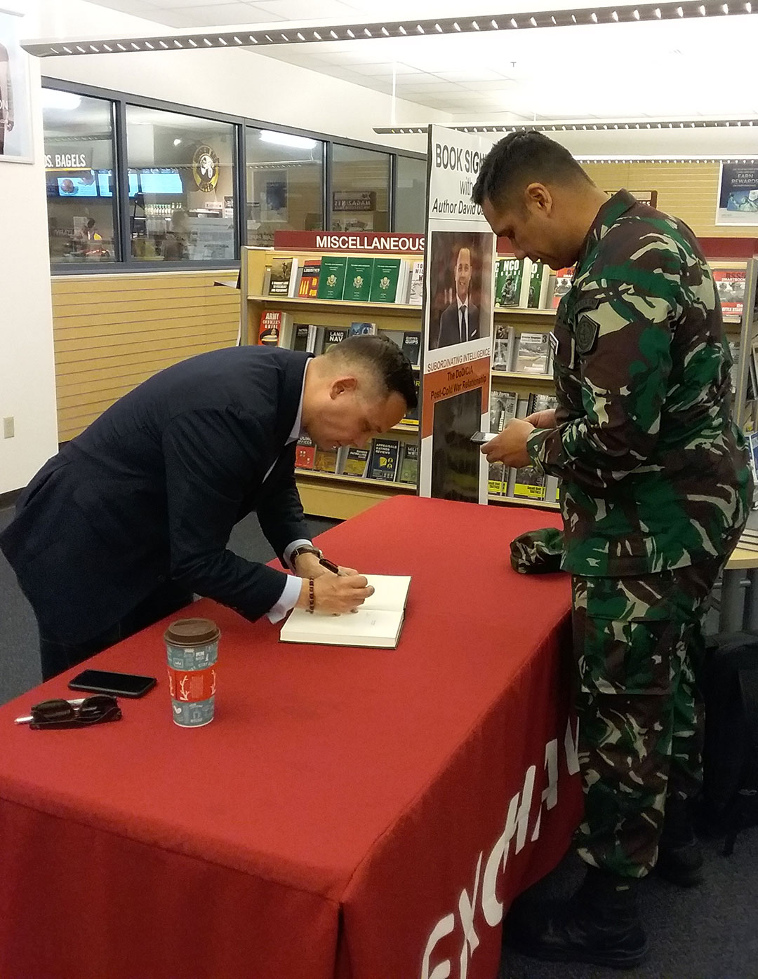 Lt. Col. David Oakley, an assistant professor at the National Defense University and author of "Subordinating Intelligence: The CIA/DoD Post-Cold War Relationship," signs his book for a CGSC student in the AAFES Bookstore in the Lewis and Clark Center on April 17.