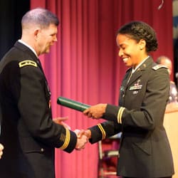 photo of Maj. Kourtney Logan looking down at her diploma during the U.S. Army Command and General Staff Officers Course Common Core graduation ceremony hosted by the 7th Intermediate Level Education Detachment, 7th Mission Support Command, in Grafenwoehr, Germany, May 17, 2019.