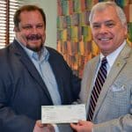 Scott Cahill, director of corporate communications for Pioneer Services, presents a donation Aug. 1 to CGSC Foundation President/CEO Rod Cox to provide support for the Foundation and its programs.