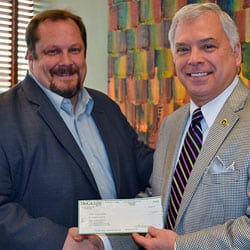 Scott Cahill, director of corporate communications for Pioneer Services, presents a donation Aug. 1 to CGSC Foundation President/CEO Rod Cox to provide support for the Foundation and its programs.