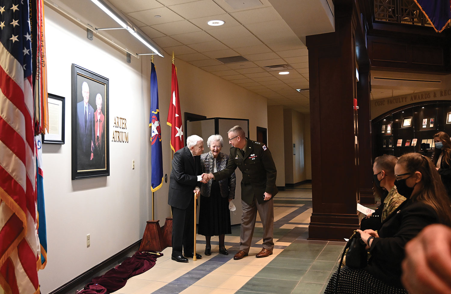 Lt. Gen. Theodore Martin, commanding general of Fort Leavenworth and the Combined Arms Center and commandant of the U.S. Army Command and General Staff College, congratulates the Arter’s after unveiling their portrait display in the Lewis and Clark Center atrium.