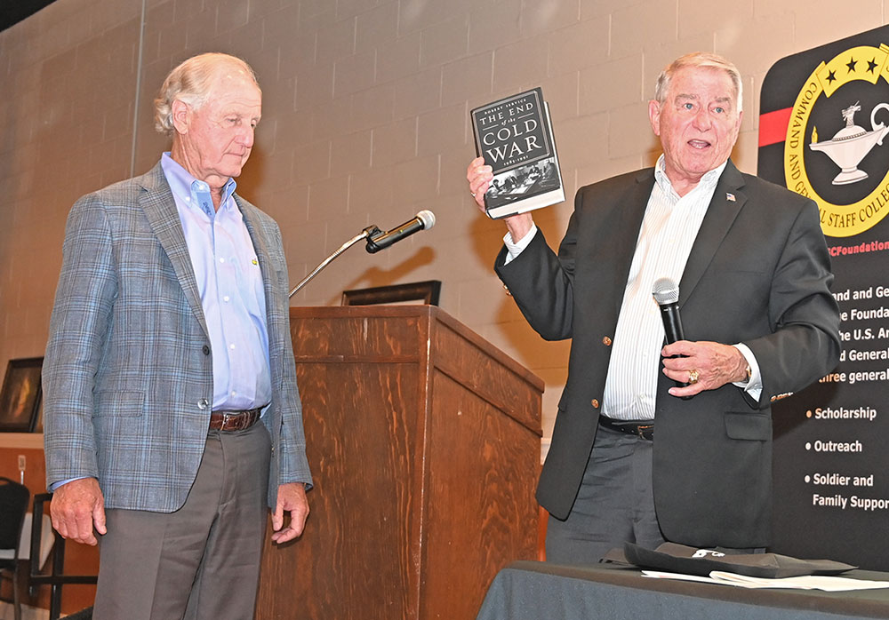 Simons Center Director Bob Ulin, right, presents John Ferguson, owner of Ferguson Hotel Development, with a copy of the book The End of the Cold War: 1985-1991 by Robert Service, as a gift for his sponsorship of the Cold War Symposium.