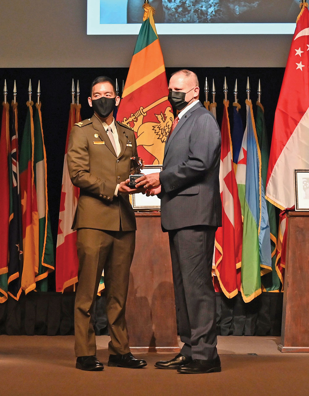 CGSC Foundation Chairman Brig. Gen. (Ret.) Bryan Wampler, right, presents an eagle statuette to Lt. Gen. Perry Lim Cheng Yeo from Singapore symbolizing his appointment as a life constituent of the CGSC Foundation during the the CGSC International Hall of Fame Induction Ceremony Nov. 16, 2021. Current CGSOC Class of 2022 student from Singapore, Maj. Joshua Goh, accepts the award on the general’s behalf.