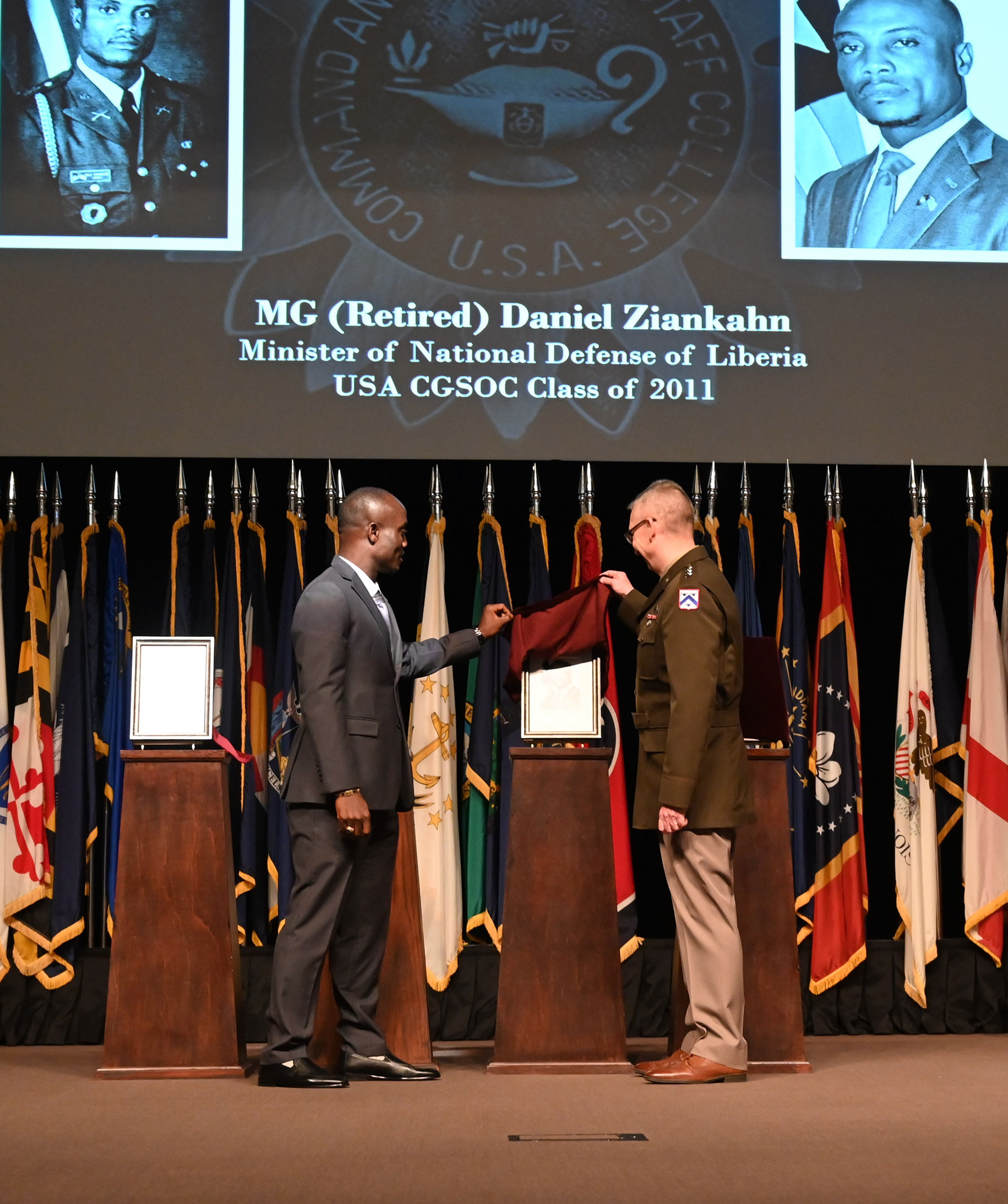 CGSC Commandant Lt. Gen. Theodore D. Martin, right, and Maj. Gen. (Ret.) Daniel Dee Ziankahn, Jr., Minister of National Defense, Liberia, unveil Ziankahn's portrait during the International Hall of Fame induction ceremony April 12, 2022, at the Lewis and Clark Center, Fort Leavenworth, Kansas.
