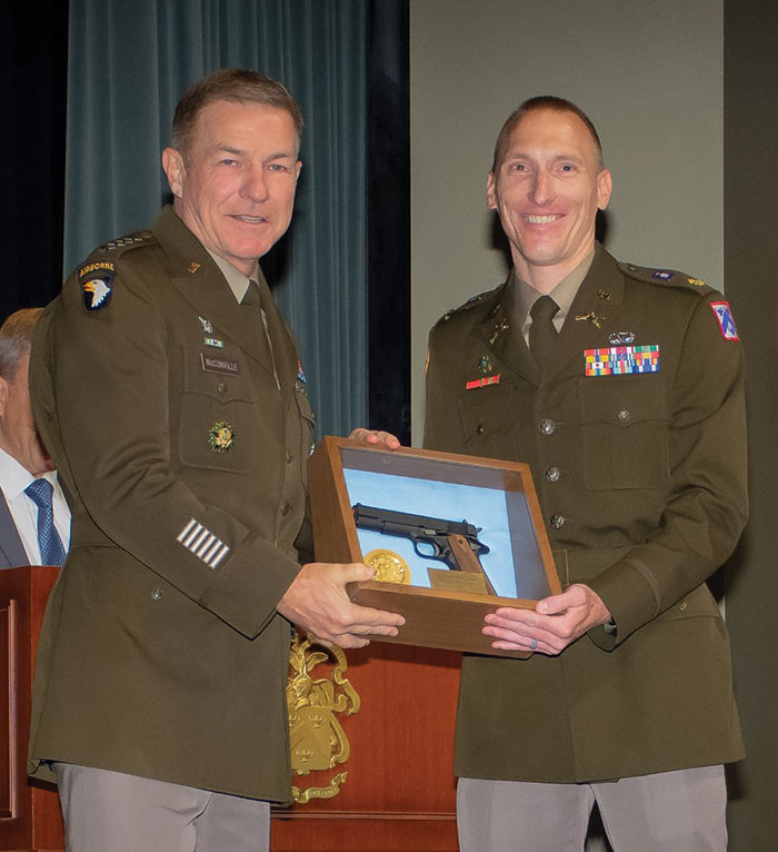 Maj. Edwin den Harder, right, receives the General George C. Marshall Award  from Chief of Staff of the Army Gen. James C. McConville during the CGSOC graduation ceremony on June 10, 2022 at Fort Leavenworth. The award is presented to the Distinguished U.S. student of each graduating CGSOC class.