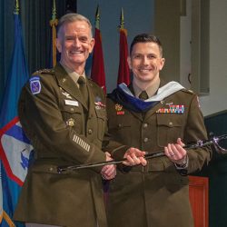 Maj. Christopher P. Zaczyk receives the Colonel Thomas Felts Leadership Award, an Army saber, from graduation guest speaker Lt. Gen. Walter E. Piatt, Director of the Army Staff, during the SAMS graduation ceremony May 26, 2022.