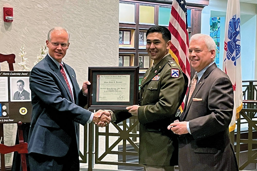 Professor Andrew Shoffner, left, presents a certificate for the 2022 Lieutenant Colonel Boyd McCanna “Mac” Harris Leadership Award to Major Robert “Bobby” L. Barnhart during a ceremony June 9 in the Lewis and Clark Center. At right is CGSC Foundation President/CEO Rod Cox.