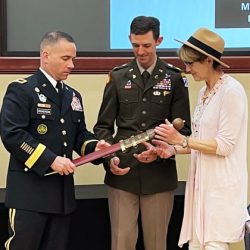 Maj. Joseph A. Bedingfield, center, receives the LTC Ronald C. Ward Distinguished Special Operations Forces Student Award, a Roman Gladius sword, signifying his selection as the top Special Operations Forces student for the Command and General Staff Officer Course Class of 2022 in a ceremony June 9 in Marshall Auditorium of the Lewis and Clark Center. Guest speaker Brig. Gen. Kelly M. Dickerson, deputy commanding general of the U.S. Army JFK Special Warfare Center and School at Fort Bragg, N.C., and Ms. Beth Ward, wife of the award’s namesake, present the award.