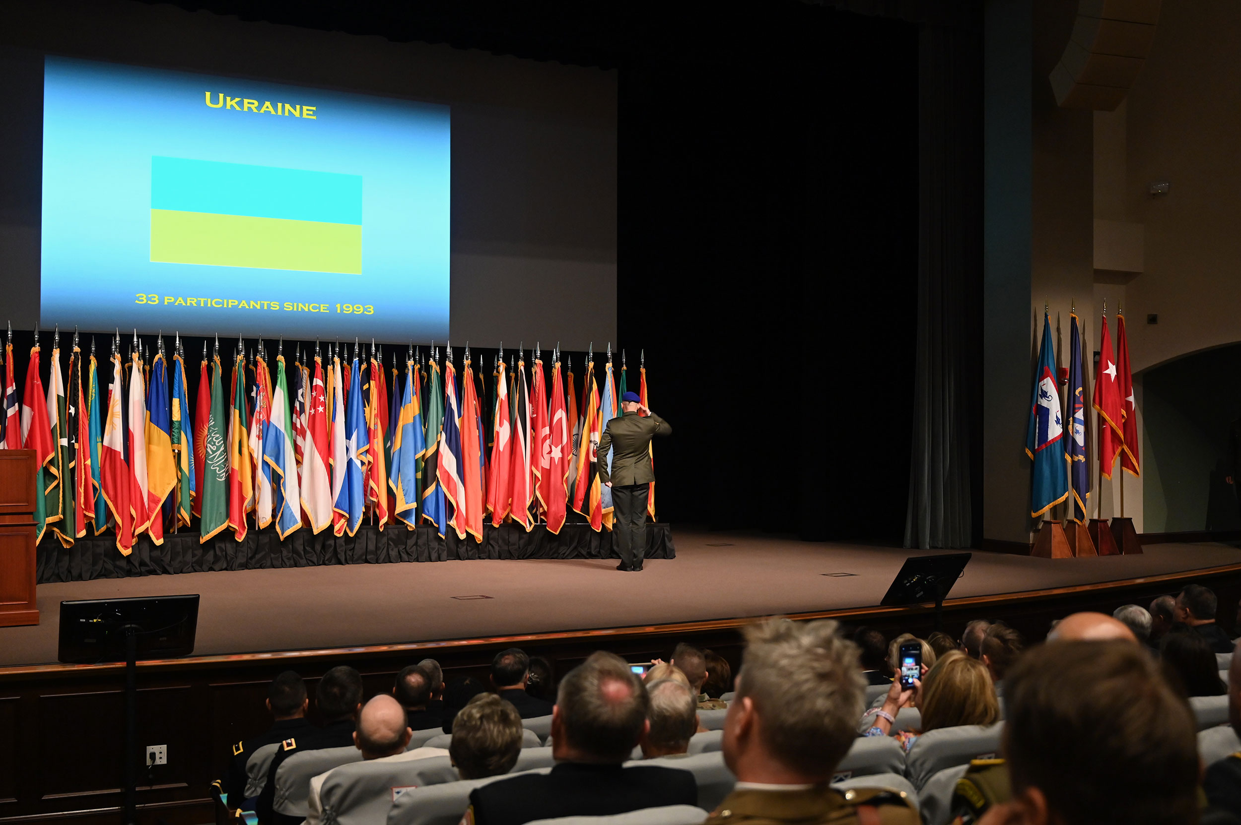 The international military student from Ukraine salutes after posting his nation’s flag during the 2023 International Flag Ceremony on Aug. 8, 2022 in the Eisenhower Auditorium of the Lewis and Clark Center.