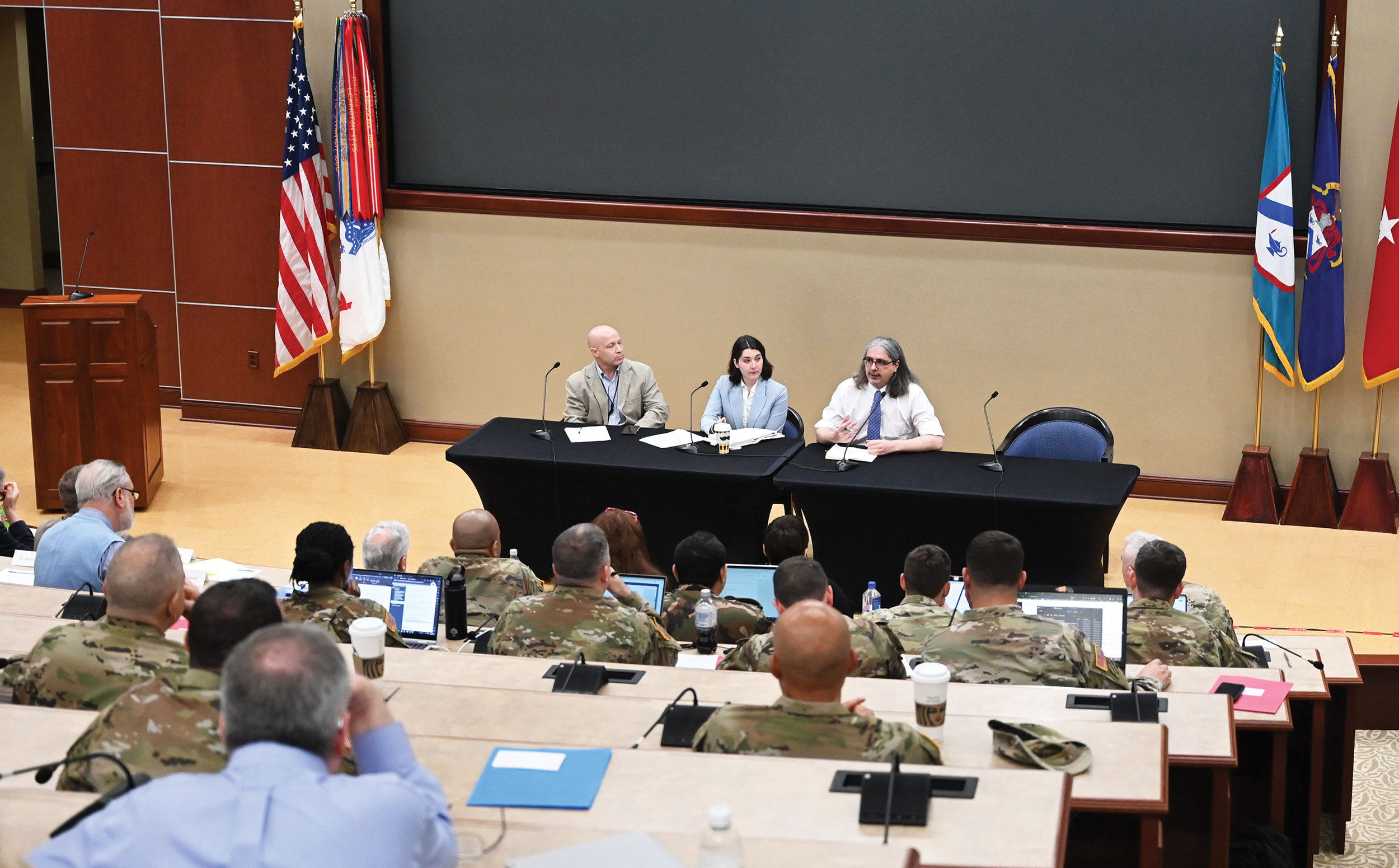 Dr. Jonathan Flint, right, research associate with the Inamori International Center for Ethics and Excellence, right, provides comments during the first panel of the 2023 CGSC Military Ethics Symposium on April 20, 2023 in the Marshall Auditorium of the Lewis and Clark Center on Fort Leavenworth. Flint presented along with Ms. Kate Kilgore, center, an intelligence analyst in the U.S. Army Training and Doctrine Command (TRADOC) G-2 (Intelligence), and Dr. Chris Marsh, left, associate professor at the Joint Special Operations Master of Arts (JSOMA) program at Fort Bragg, a division of the College of International Security Affairs of the National Defense University.