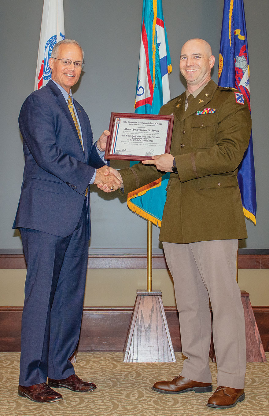 Major Sebastian Welsh, M.D., right, receives the Lieutenant Colonel Boyd McCanna “Mac” Harris Leadership Award for the Command and General Staff Officer Course (CGSOC) Class of 2023 in a ceremony conducted in the Arnold Conference Room of Lewis and Clark Center on June 8, 2023. Professor Andrew Shoffner, left, director of the Command and General Staff School Department of Command and Leadership presents the award to Welsh.