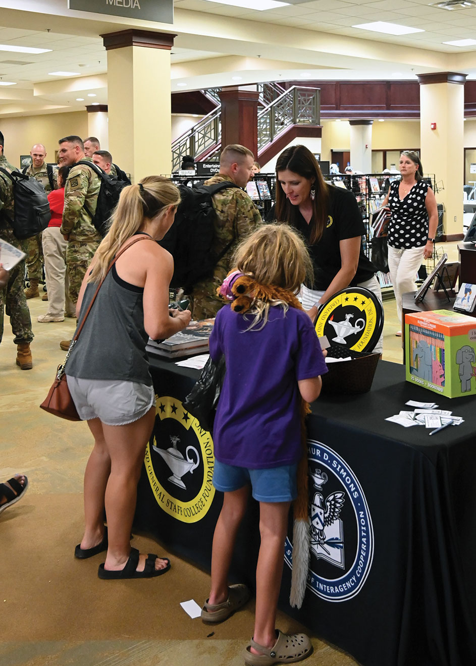 Foundation Director of Operations Lora Morgan assists a family in signing up for door prizes during the Ike Skelton Combined Arms Research Library open house on Aug. 11, 2023.