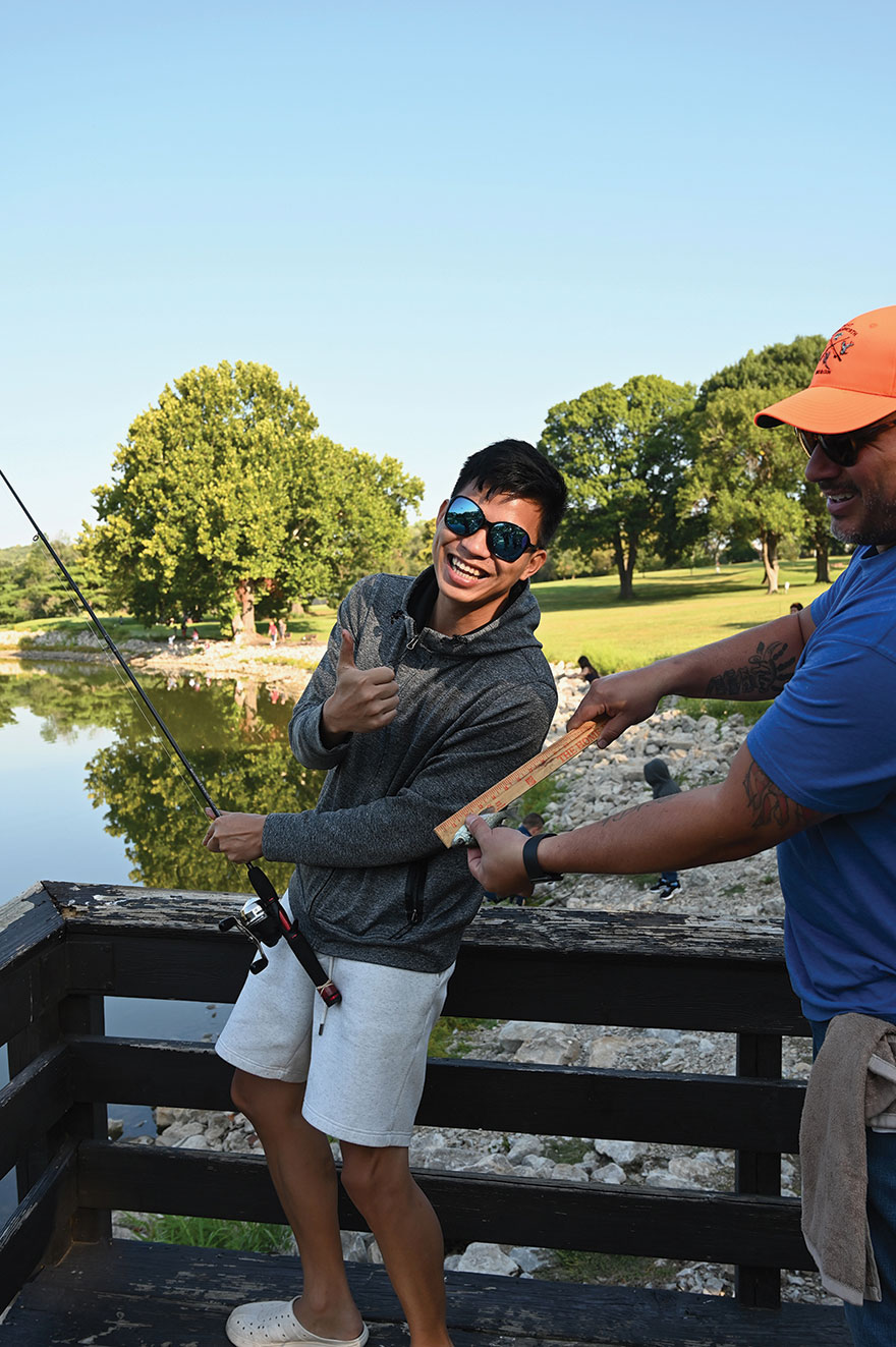 Maj. JJ Jiang, Taiwanese army officer enrolled in the Command and General Staff Officers Course Class of 2024, gets a laugh at the “sea monster” he reeled in during the International Family Fishing Derby Sept. 9, 2023, at Merritt Lake on Fort Leavenworth.
