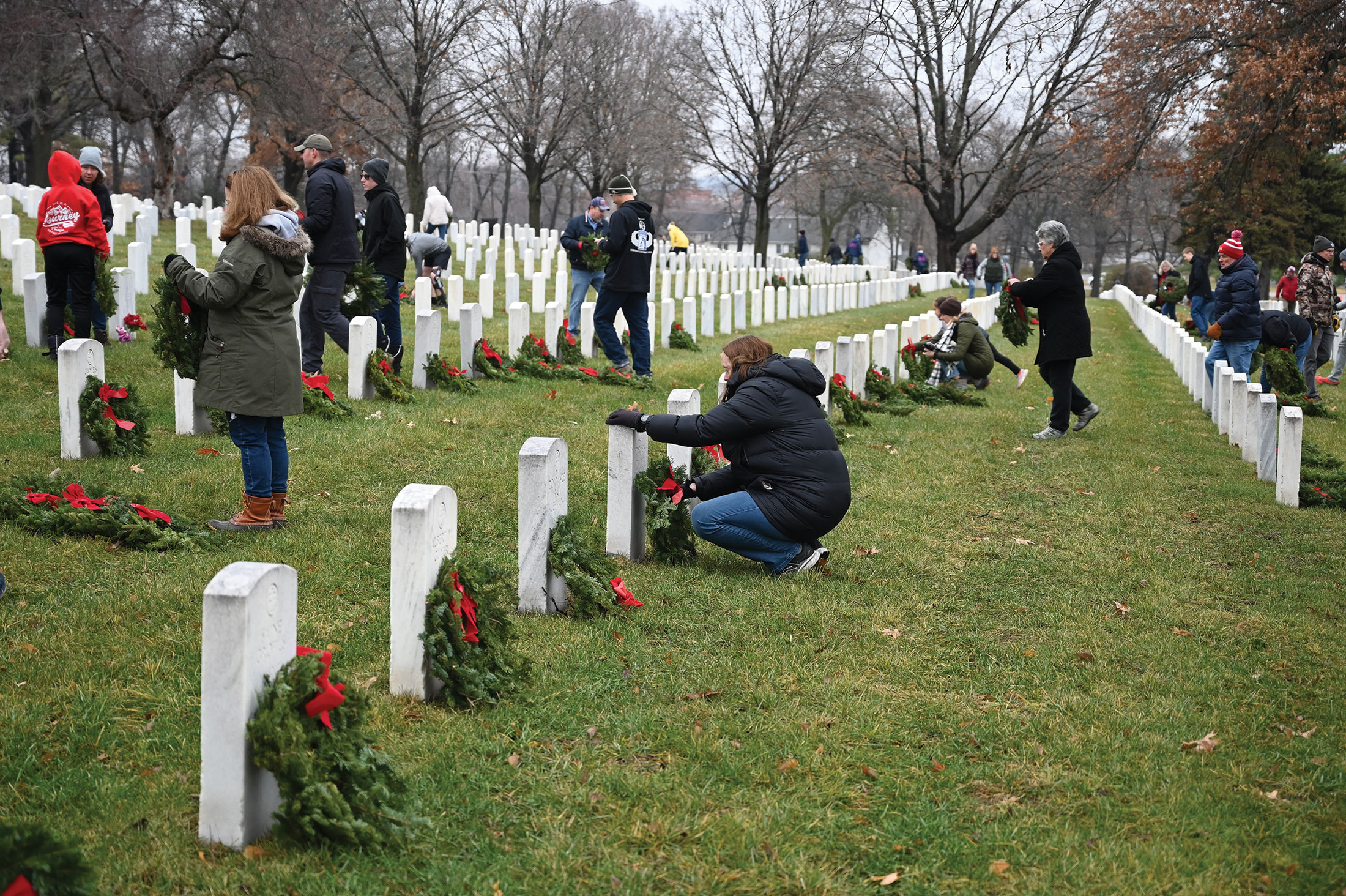 Volunteers lay wreaths on veterans' graves during national Wreaths Across America Day, Dec. 16, 2023, at the Fort Leavenworth National Cemetery.