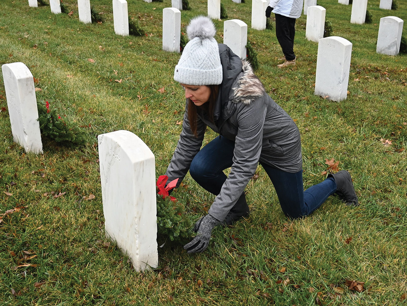 CGSC Foundation Interim President/CEO Lora Morgan places a wreath to honor a veteran on national Wreaths Across America Day, Dec. 16, 2023, at the Fort Leavenworth National Cemetery.