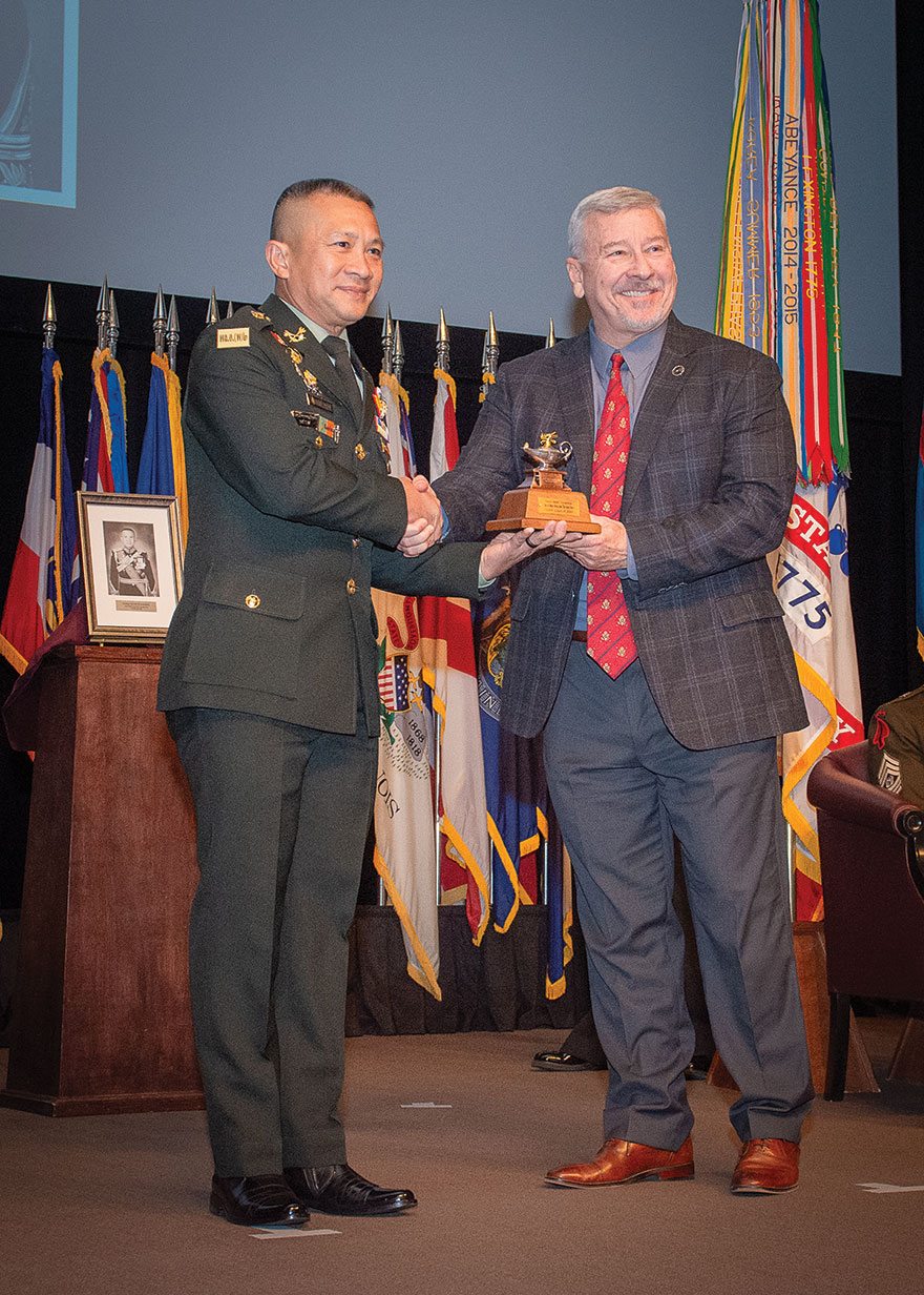 IHOF w CGSC Foundation Chair Maj. Gen. (Ret.) Chris Hughes presents Gen. Songwit Noonpackdee, Chief of Defense Forces, Royal Thai Armed Forces, with a gift of a miniature Fort Leavenworth Lamp designating him as an honorary life constituent of the CGSC Foundation during the International Hall of Fame induction ceremony April 2, 2024, at the Lewis and Clark Center, Fort Leavenworth, Kansas.