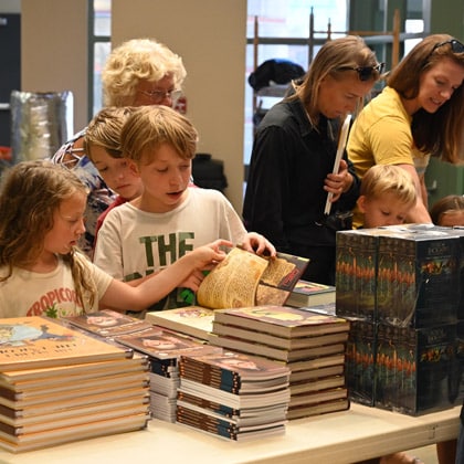Kids try to make a decision on which free book to pick during the “Check out your library” event at the Ike Skelton Combined Arms Research Library open house on Aug. 5, 2024.