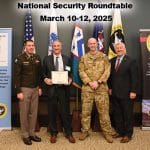 NSRT px CGSC Deputy Commandant Col. Jason Rosenstrauch, left, and CGSC Foundation Chair Maj. Gen. (Ret.) Chris Hughes, far right, present Dave Keith, president and CEO of the Wellabe Corporation in Des Moines, Iowa, second from left, with a graduation certificate for the 2025 National Security Roundtable conducted March 10-12, 2025, at Fort Leavenworth. To the right of Keith is his NSRT escort officer, U.S. Air Force Maj. Sean "Bob" Vincent, a student in the Command and General Staff Officers Course Class of 2025.