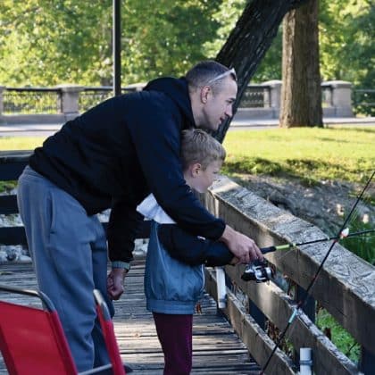Capt. Alex Sinicic, an international military student from Slovenia in the CGSOC Class of 2026, helps his son Amai, 5, mind the rod during the fifth annual International Family Fishing Derby on Sept. 6, 2025, at Fort Leavenworth's Merritt Lake.
