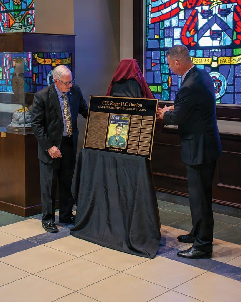 Dr. Dave Cotter, Dean of Academics, U.S. Army Command and General Staff College, left and Dr. Michael Forsyth, Director of the Department of Command and Leadership, CGSC, right, unveil the plaque representing the new Col. Roger H.C. Donlon Chair for Military Leadership Studies Distinguished Chair in a ceremony March 25, 2026, at the Lewis and Clark Center on Fort Leavenworth. Forsyth is the first person to be designated to hold the chair title and responsibilities. (U.S. Army photo by Jim Shea)