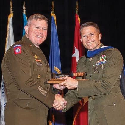 Army University President/Commanding General Maj. Gen. Trevor Bredenkamp, left, presents Lt. Col. Tyler B. Folan with the Col. Michael "Scott" Flurry Award during the School of Advanced Military Studies graduation ceremony May 21, 2026, in the Lewis and Clark Center.