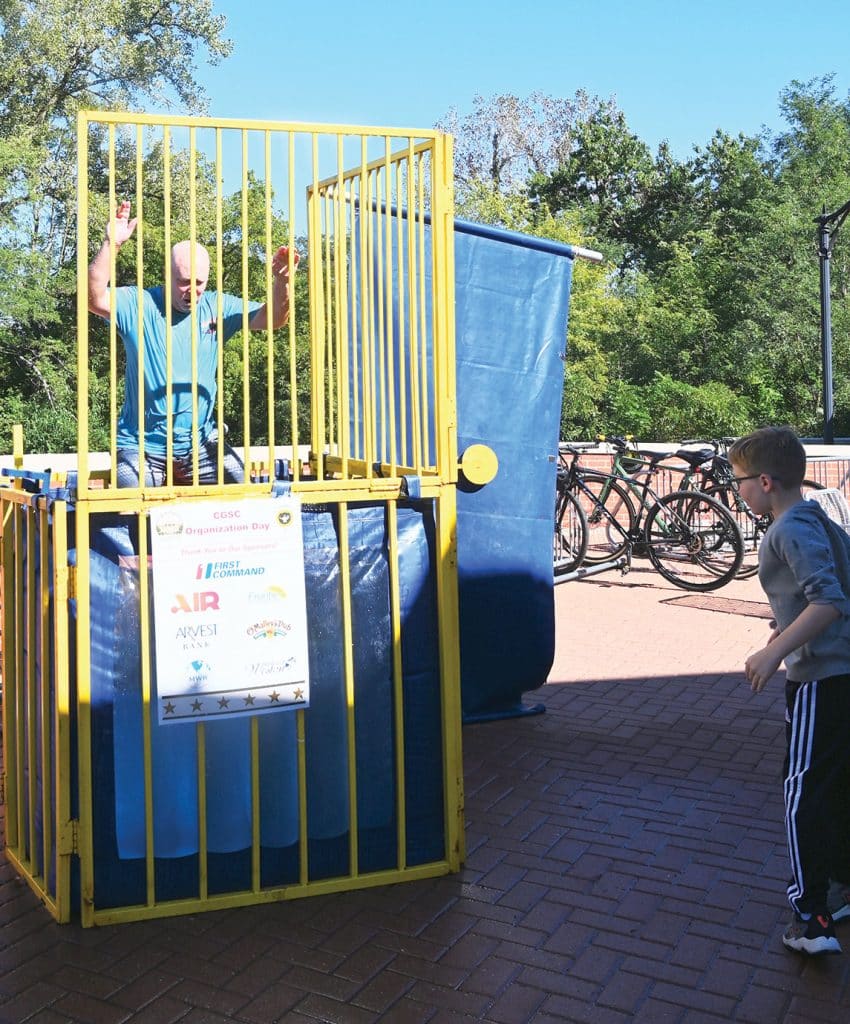 A young family member sends CGSC Associate Dean of Academics Greg Penfield into the drink during the CGSC Organization Day hosted by the CGSC Foundation and Alumni Association on the Lewis and Clark Center patio Oct. 2, 2026.