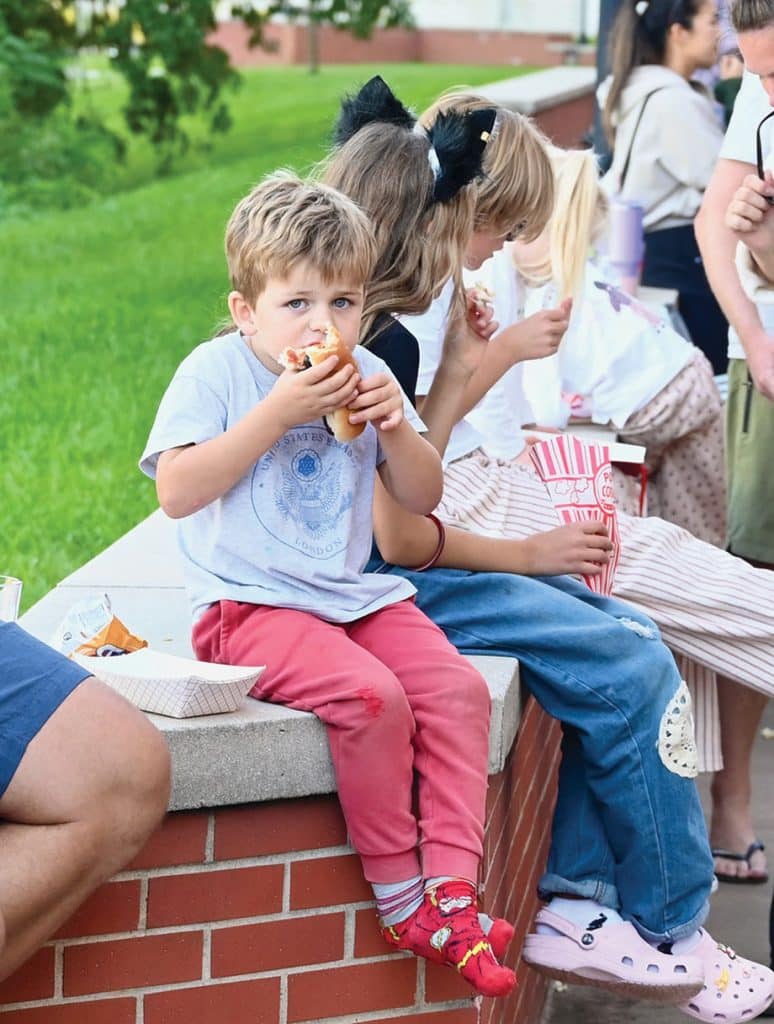 A young CGSC family member enjoys one of the hundreds of hotdogs served during  CGSC Organization Day hosted by the CGSC Foundation and Alumni Association on the Lewis and Clark Center patio Oct. 2, 2026.